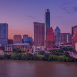 Venture-Forge-Austin-Skyline.jpg - Venture Forge Austin city skyline at sunset, with buildings reflecting warm hues and a river in the foreground.
