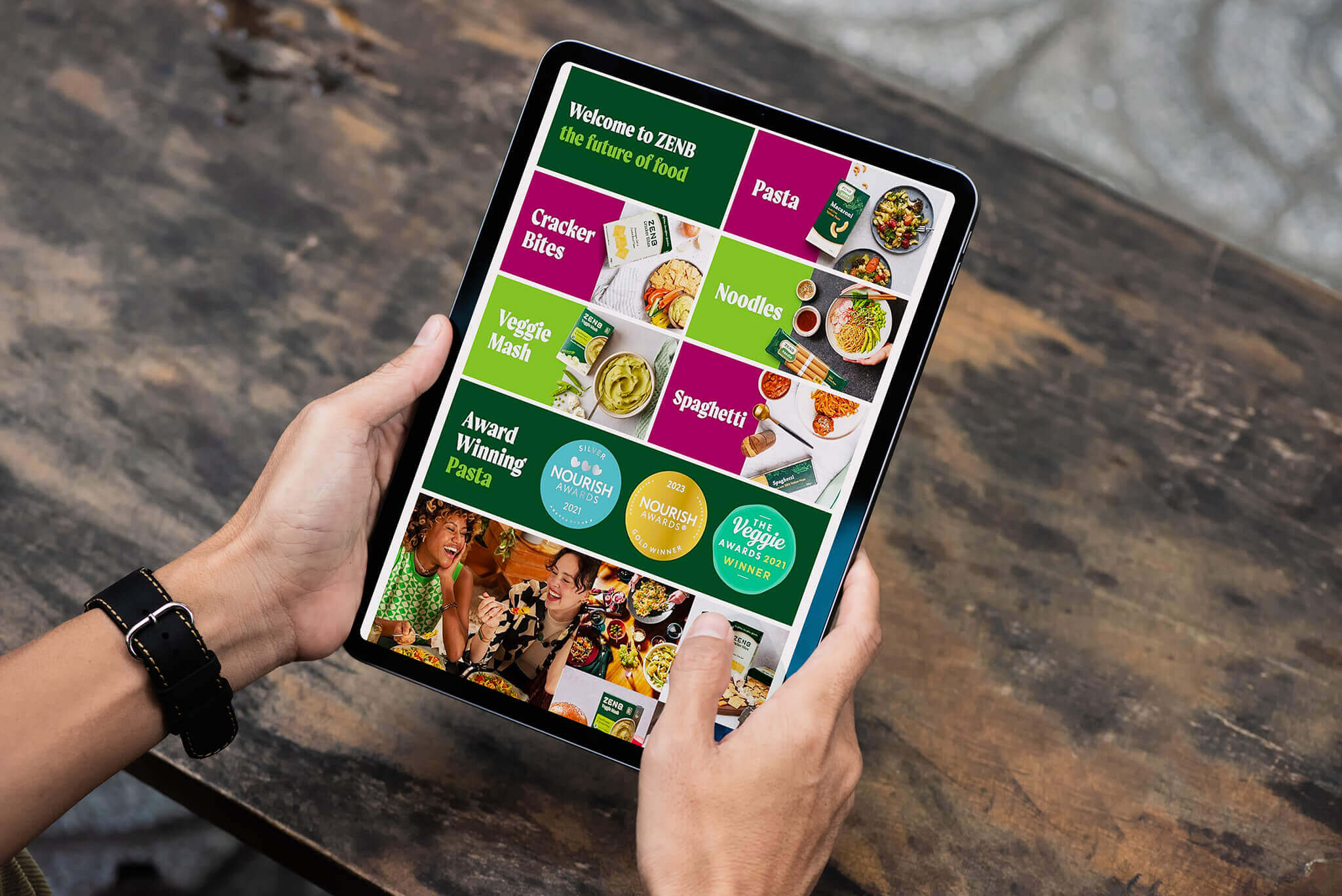 Person holding tablet displaying ZENB product range and awards, representing food brand content examples on Amazon.