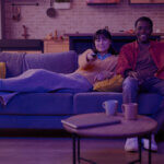 Amazon Prime Video Ads: A Game-Changer for Brands in 2025 - Venture Forge A young couple relaxing on a couch, watching TV.
