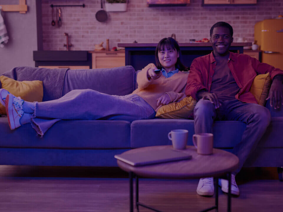Amazon Prime Video Ads: A Game-Changer for Brands in 2025 - Venture Forge A young couple relaxing on a couch, watching TV.