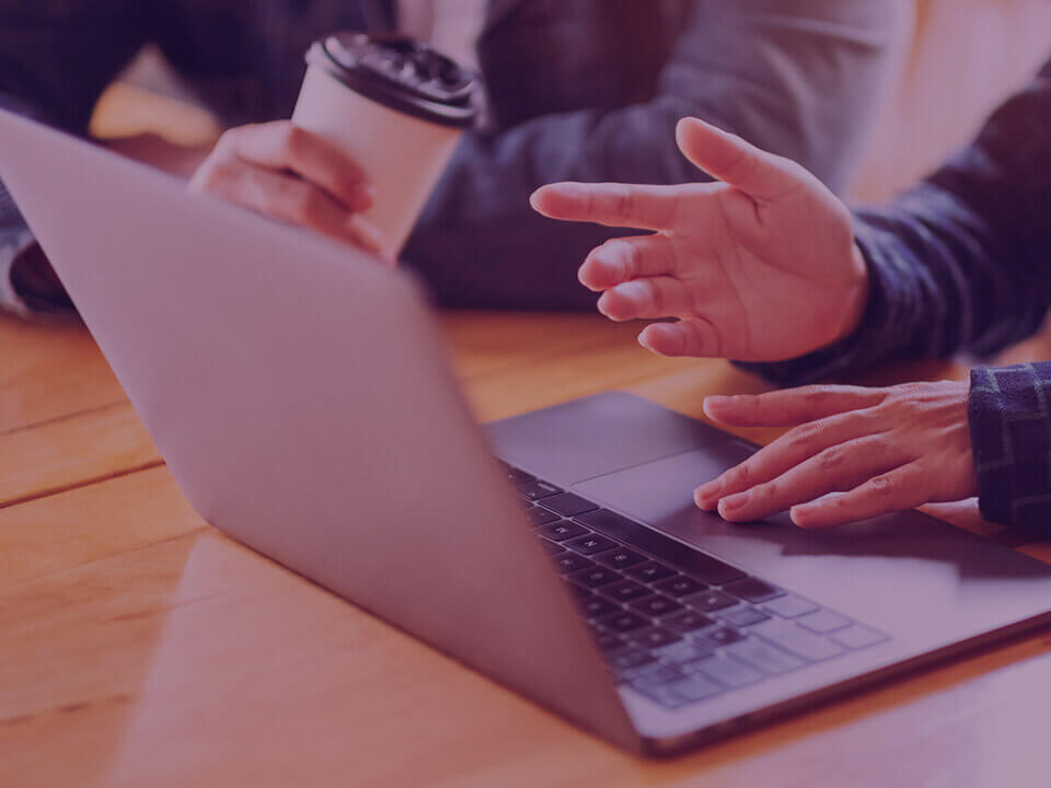 Two team members having a meeting and reviewing Amazon storefront on laptop