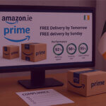 An Irish flag on a desk next to a computer screen displaying the new delivery rules on Amazon.ie.