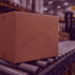 Cardboard box on a warehouse conveyor belt with a subtle rising cost symbol, representing increasing Amazon fulfilment costs.