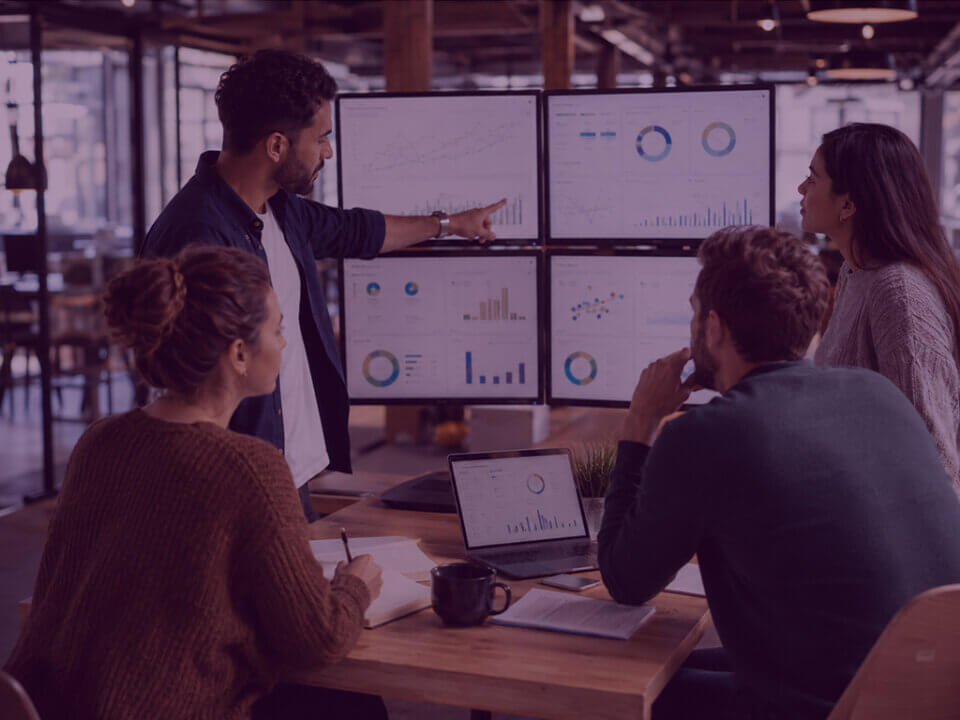 A strategic seller account management team reviews Amazon-style performance dashboards in a collaborative agency workspace.