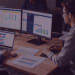 What your Prime Day Performance Data is really telling you Venture Forge - Venture Forge Team of two analyzing data on three screens and a laptop, with charts and graphs on the desk.