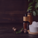 How K-beauty took a quarter of Amazon UK Skincare in a week Venture Forge - Venture Forge Natural spa scene with a white bowl of bath salts, amber bottles with wooden tops, walnuts, and green leaves on a dark wooden surface.